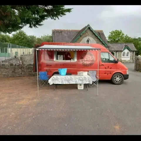Ferdie with the awning out outside the Old School, Capel Dewi