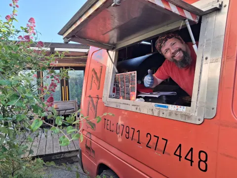 Simon smiling out of the serving hatch